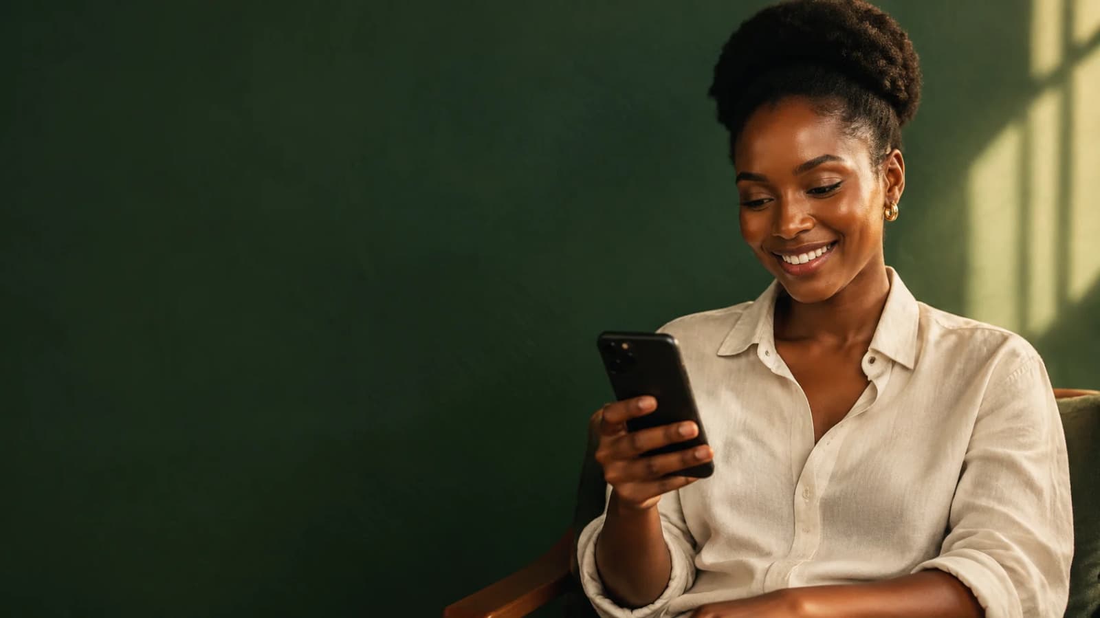 Young Ugandan woman smiling at her phone